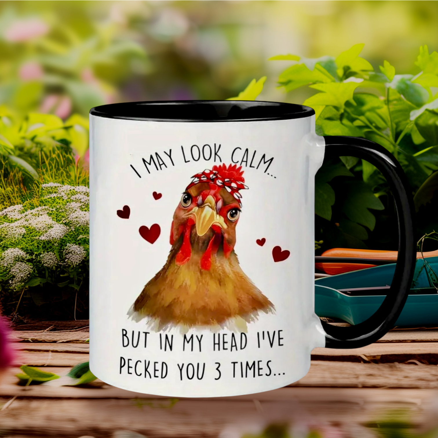 Mug with a rooster design and humorous text - I MAY LOOK CALM... in a garden setting