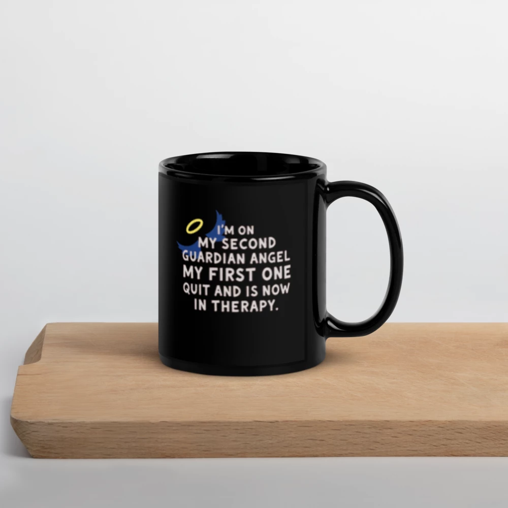 “I’m on my second guardian angel…” (Black Glossy Mug with halo)