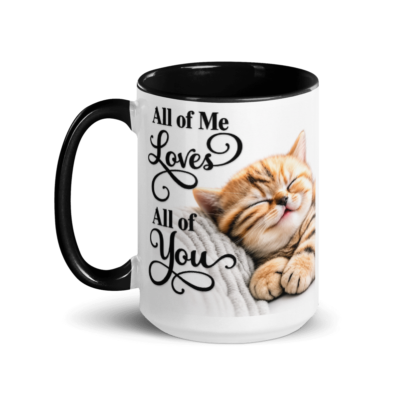 A white ceramic mug with a black handle and black interior, featuring a printed design of a sleeping orange tabby kitten and the text 'All of Me Loves All of You' in black script.