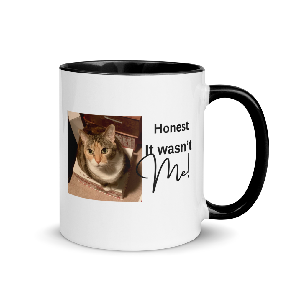 A white ceramic coffee mug with a black interior, black handle, and printed graphic featuring a tabby cat and the text 'Honest It wasn't Me!' on a white background.