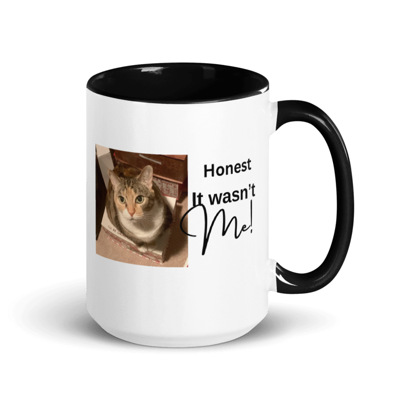 A white ceramic mug with a black interior, black handle, and printed graphic featuring a cat photo and the text 'Honest It wasn't Me!' on a white background.
