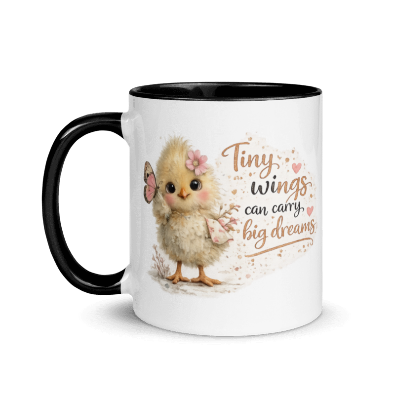 A white ceramic mug with a black handle and black interior, featuring a cute illustration of a fluffy yellow chick with a pink flower in its hair and the text 'Tiny wings can carry big dreams' in brown and BLACK lettering.