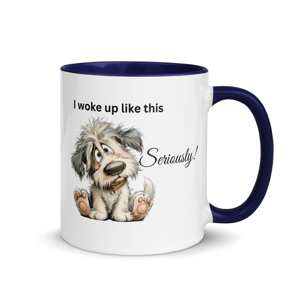 A white ceramic coffee mug with a dark navy blue interior, handle, and rim. The front of the mug features a cartoon illustration of a scruffy gray and white dog sitting up, with the text 'I woke up like this Seriously!' printed in black.