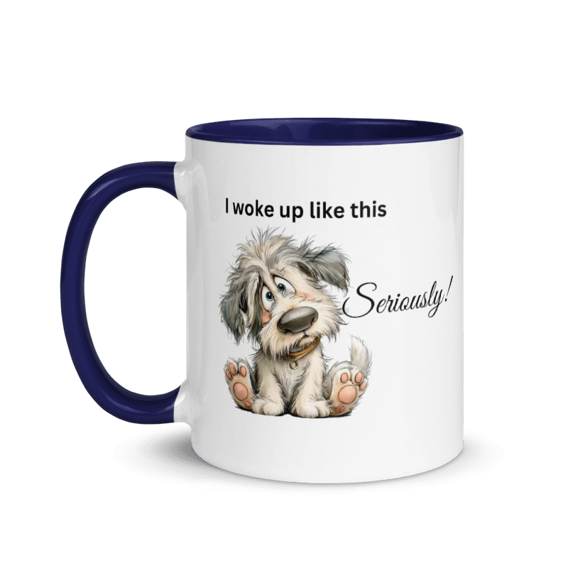 A white ceramic coffee mug with a dark navy blue handle and interior, featuring a cartoon illustration of a fluffy gray and white dog sitting down with the text 'I woke up like this Seriously!' printed on the side.