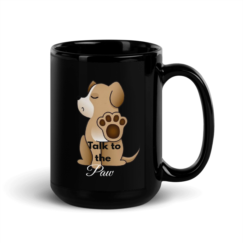 A glossy black ceramic mug featuring a cartoon puppy graphic with a raised paw and the text 'Talk to the Paw' printed on the side