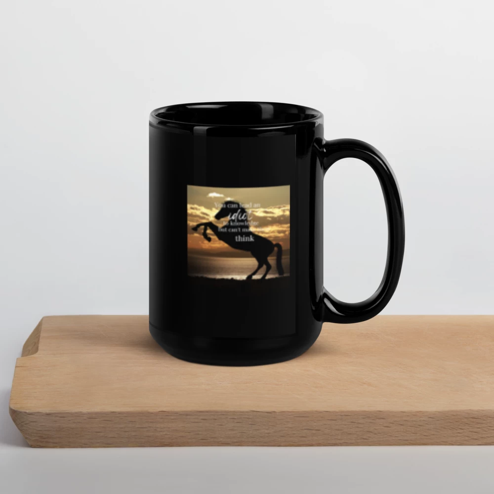 Black mug with a scenic design of a horse on a wooden surface