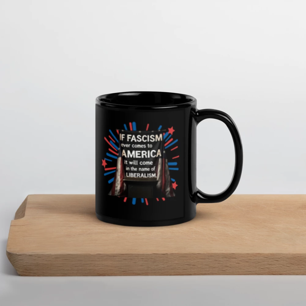 Black mug with a political quote design on a wooden surface with a light gray background