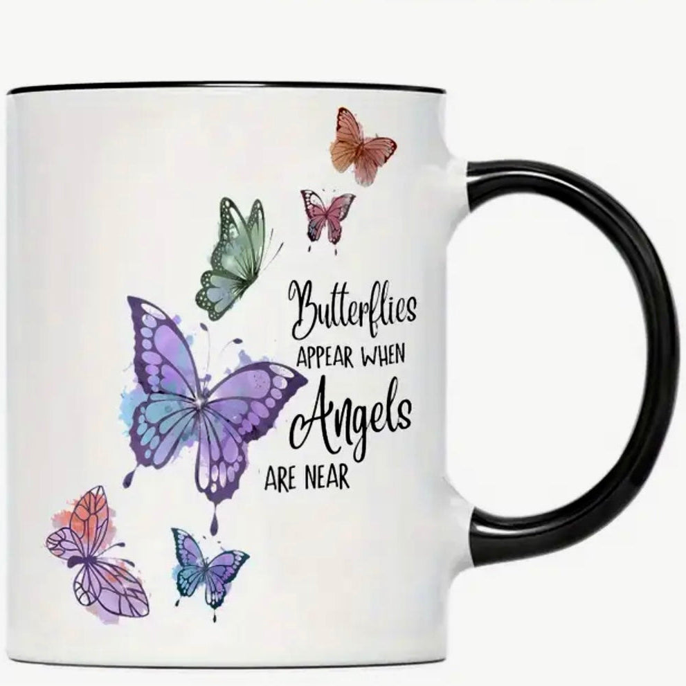 White mug with black handle featuring colorful butterfly illustrations and text on a white background