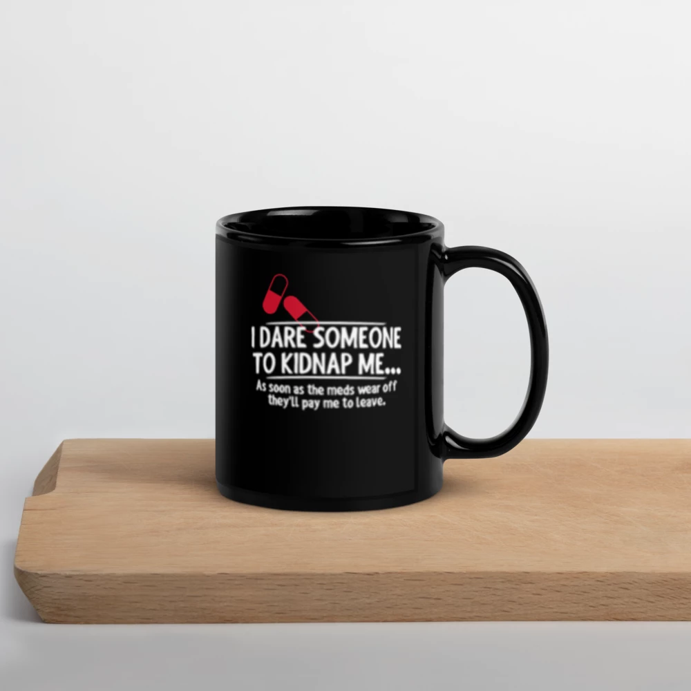 Black mug with humorous text design on a wooden surface
