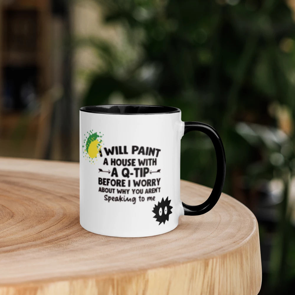 White mug with black interior and handle on a wooden surface with a blurred green plant background