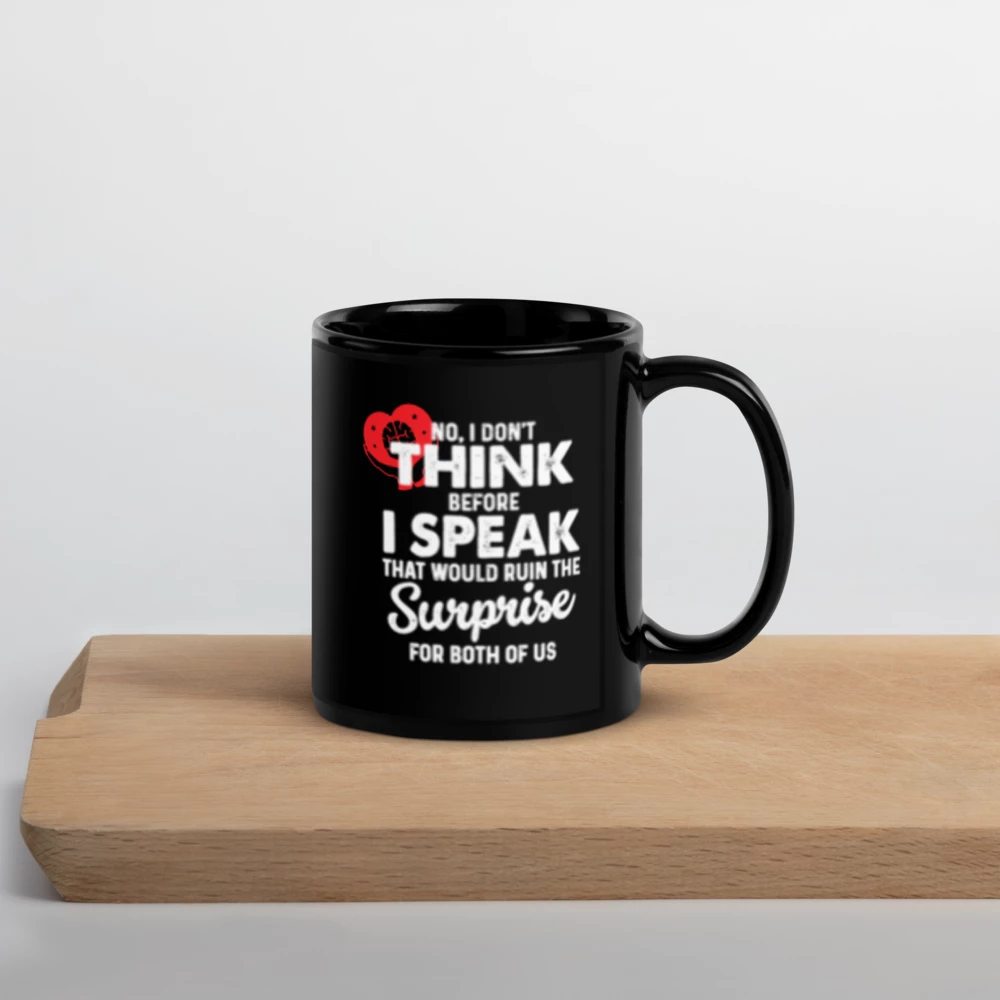 Black mug with white text on a wooden surface