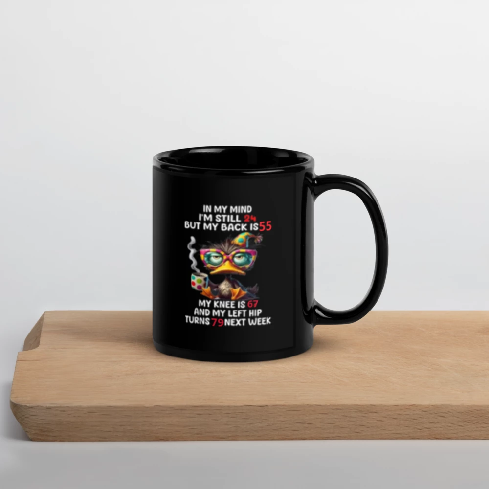 Black mug with colorful text design on a wooden surface