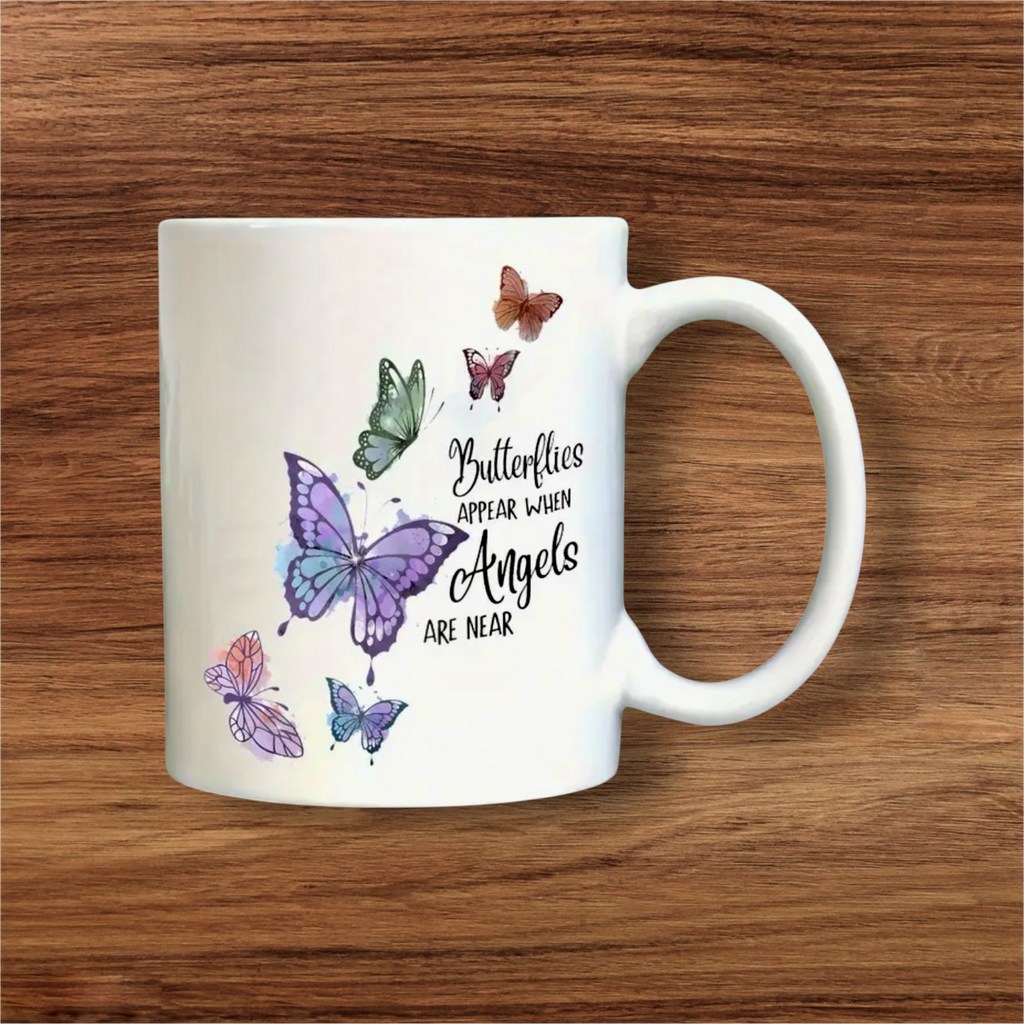 White mug with butterfly designs and text on a wooden surface