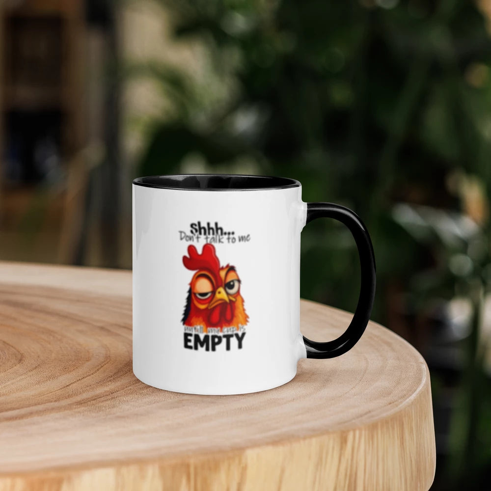 Mug with a cartoon chicken design and text on a wooden surface