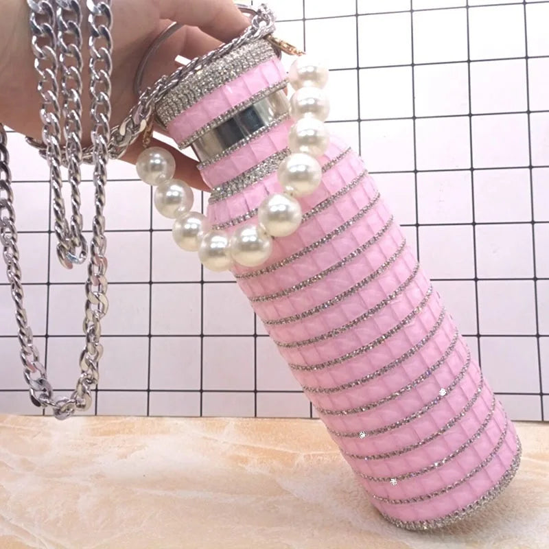 Pink water bottle with pearl and chain details on a checkered background
