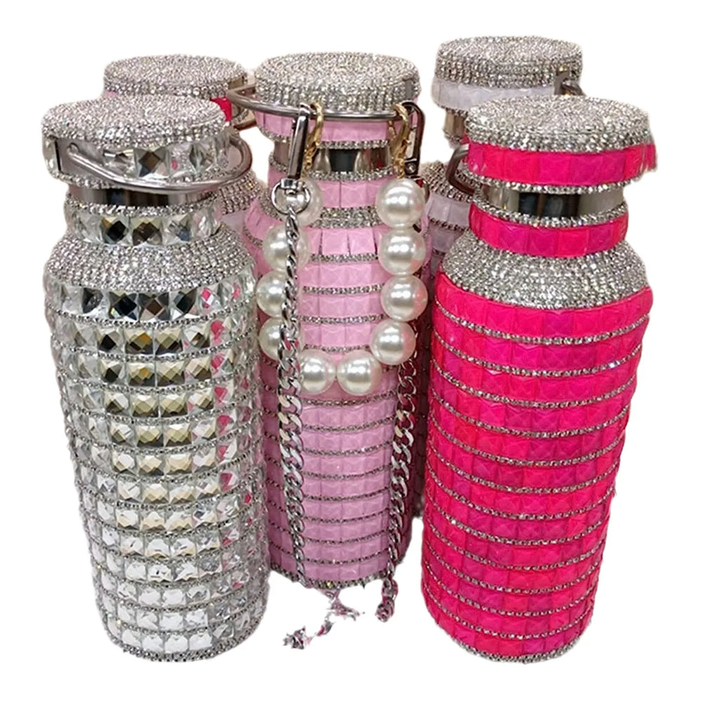 Blinged-out water bottles in silver, pink, and hot pink on a white background.