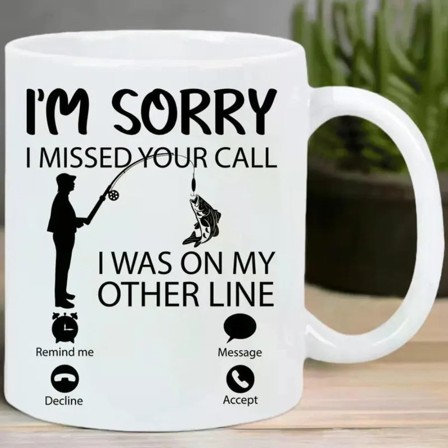 White mug with fishing-themed text and icons on a wooden surface.