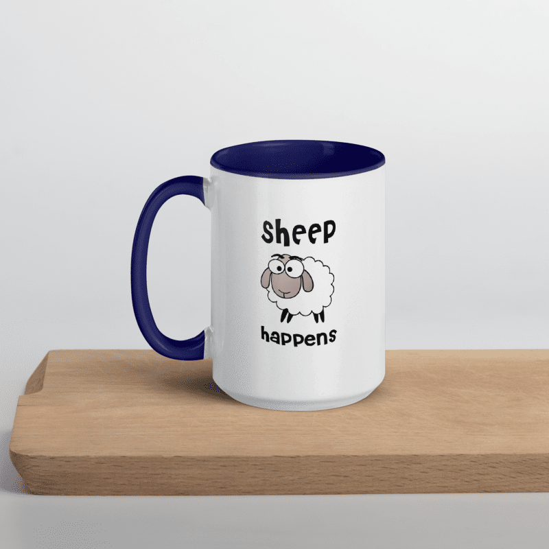 Mug with blue handle and interior, featuring a cartoon sheep and text 'Sheep happens' on a white background.