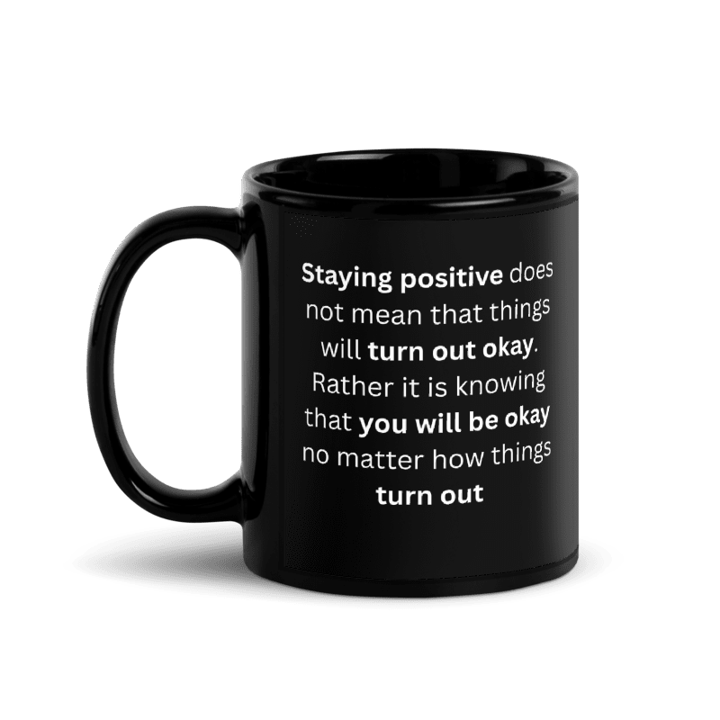 A black ceramic mug with a white printed quote on the side