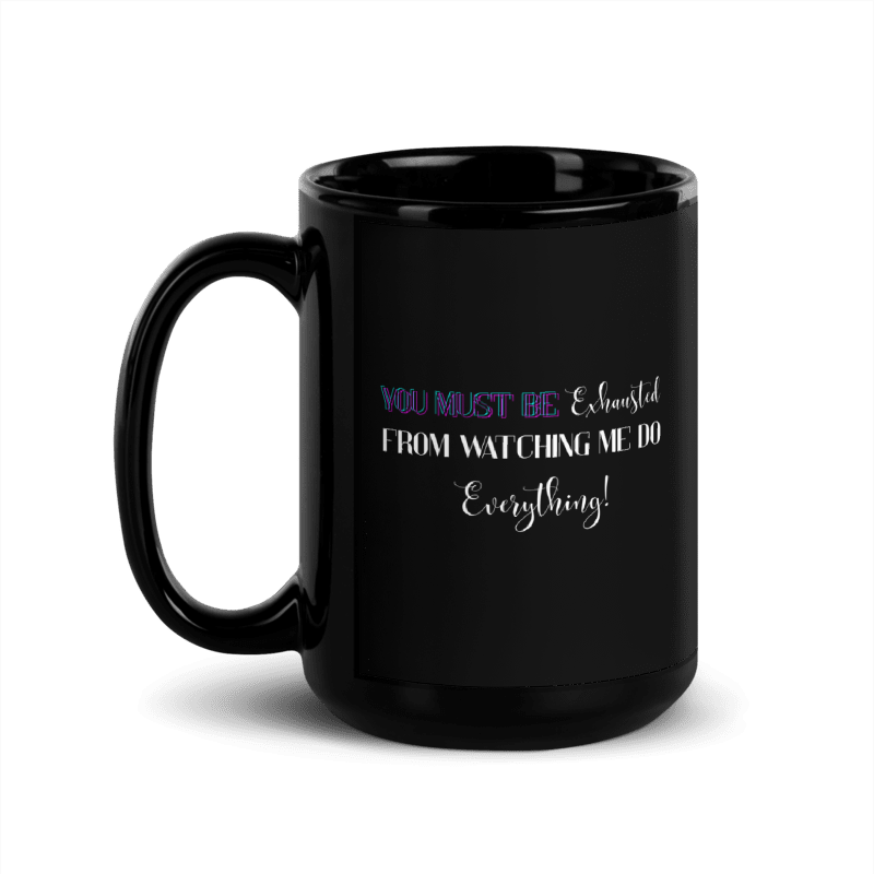 A glossy black ceramic mug with a handle on the left, featuring the printed text 'YOU MUST BE Exhausted FROM WATCHING ME DO Everything!' in purple, white, and black lettering