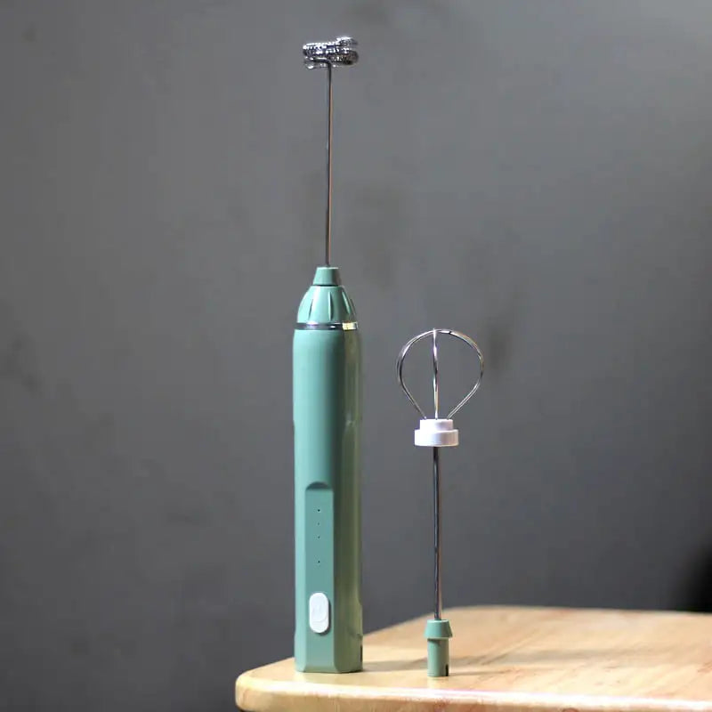 Turquoise handheld electric mixer on a wooden surface with a gray background