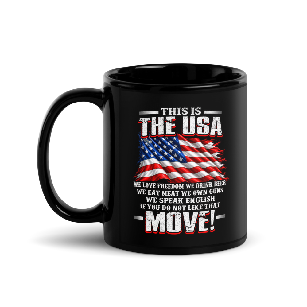 A black ceramic mug with a patriotic graphic on the front, featuring a distressed American flag and the text 'THIS IS THE USA' and 'WE LOVE FREEDOM WE DRINK BEER WE EAT MEAT WE OWN GUNS WE SPEAK ENGLISH IF YOU DO NOT LIKE THAT MOVE!'.