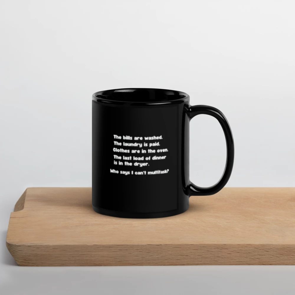 Black mug with text on a wooden surface 